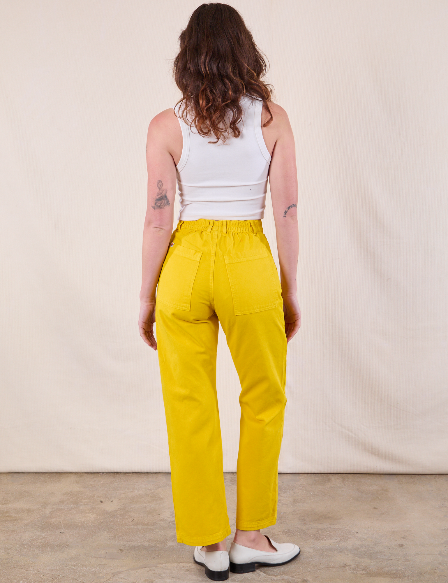 Back view of Work Pants in Golden Yellow and Cropped Tank in Vintage Tee Off-White on Alex