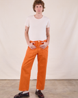 Quinn is wearing Work Pants in Construction Orange and Burly Tee in vintage tee off-white