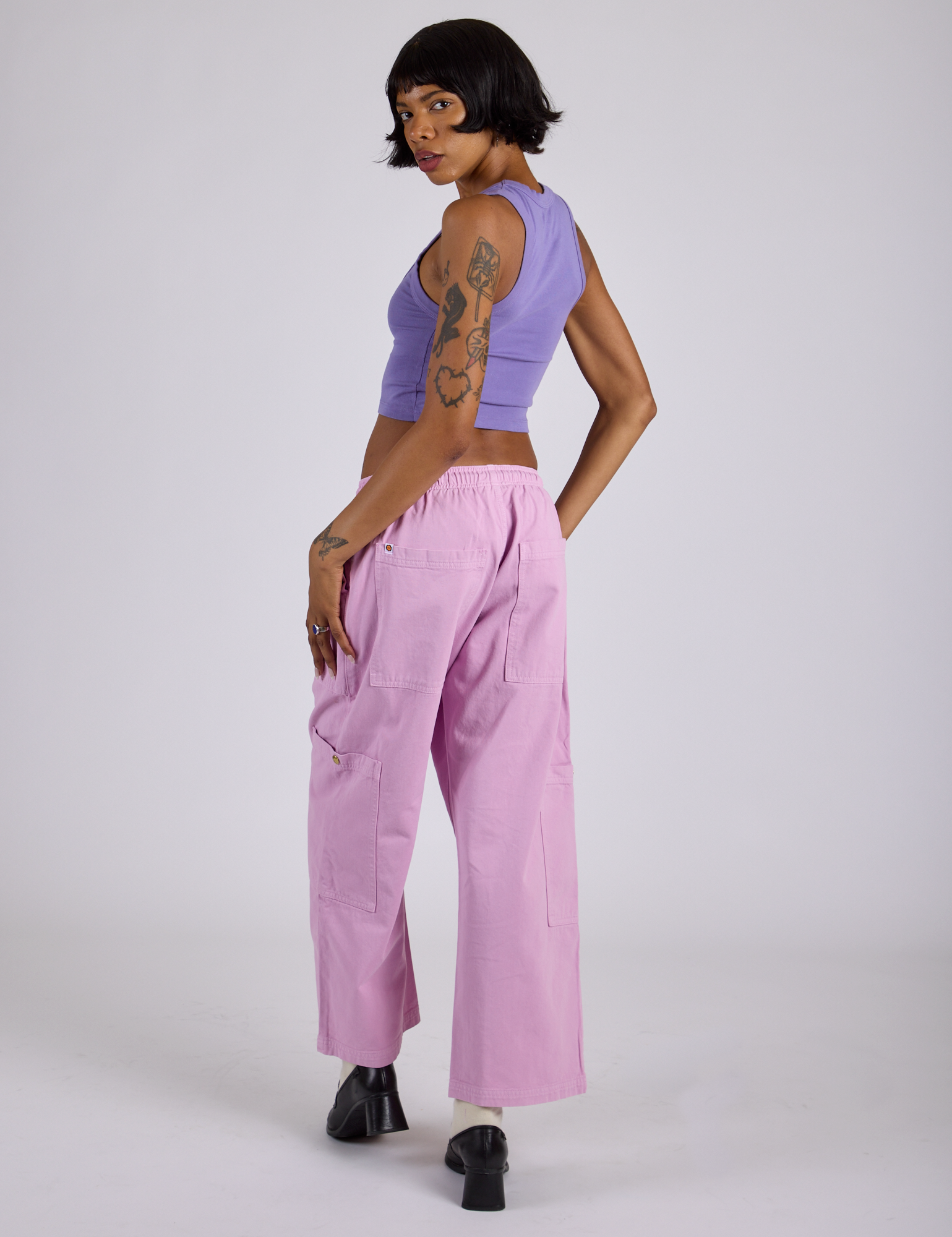 Angled back view of Drop Pocket Cargo Pants in Lilac Purple and faded grape Cropped Tank on Kira