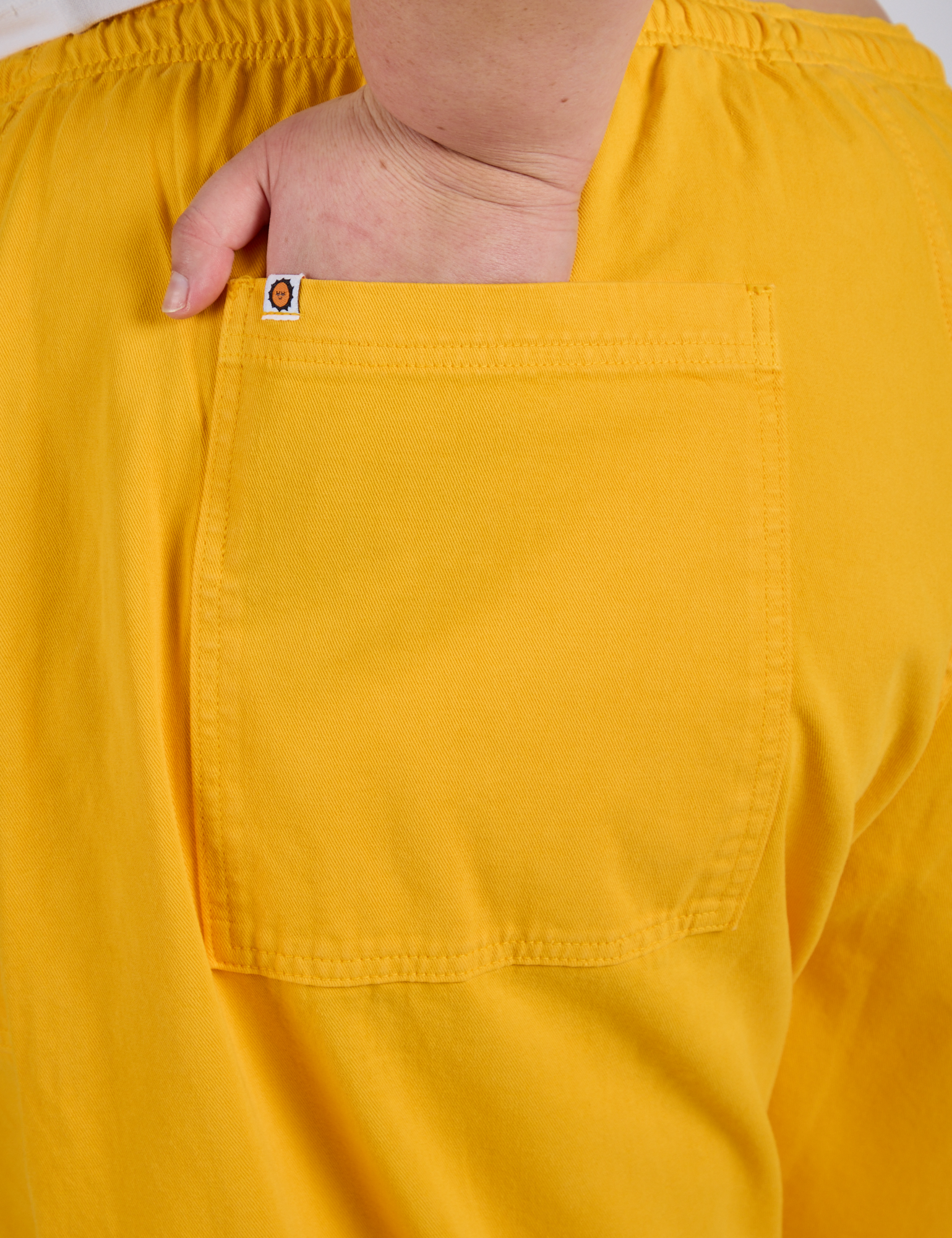Close up of Juliet's hand in the back pocket of Drop Pocket Cargo Pants in Sunshine Yellow