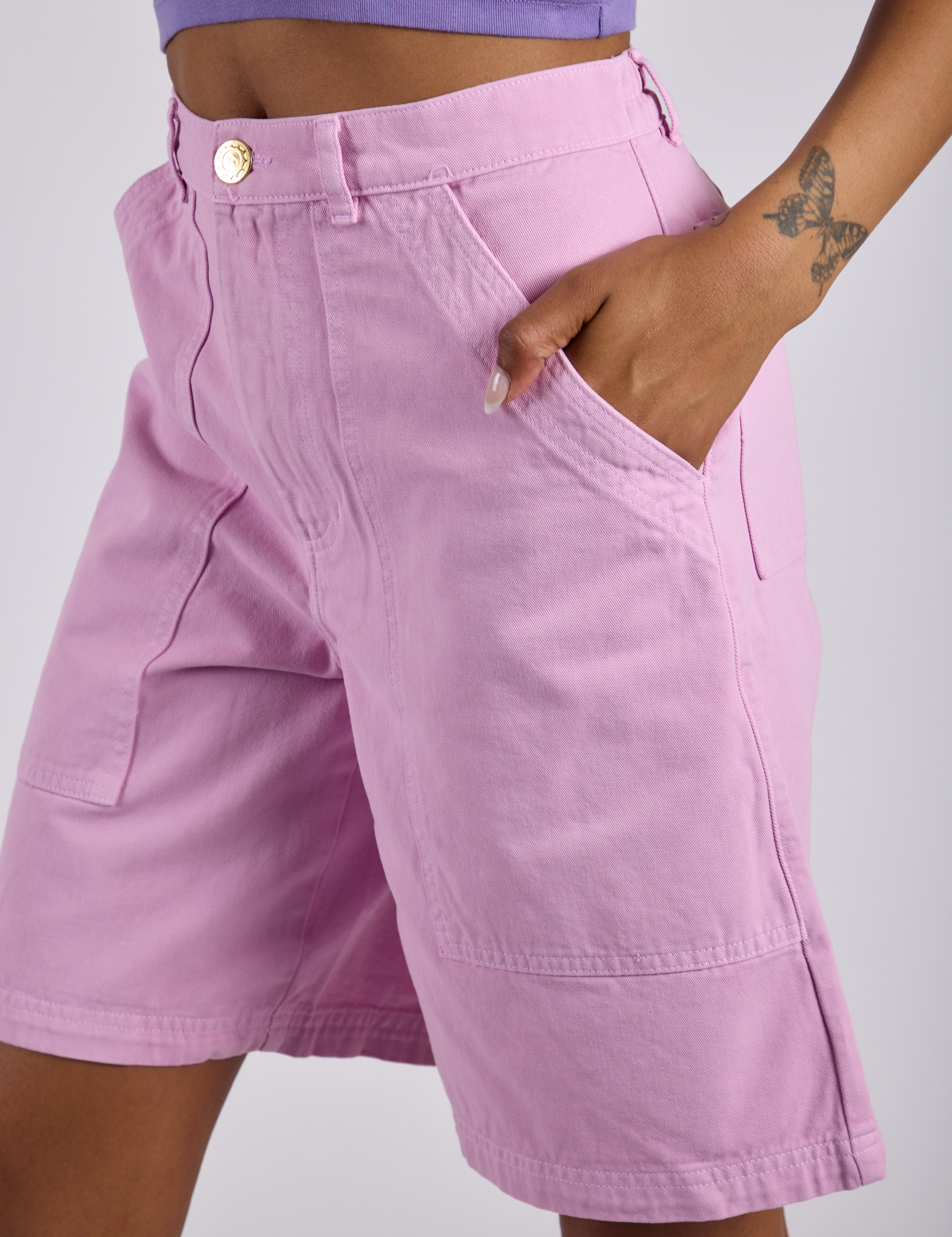 Close up of Kira's hand in the front pocket of Longline Work Shorts in Lilac Purple