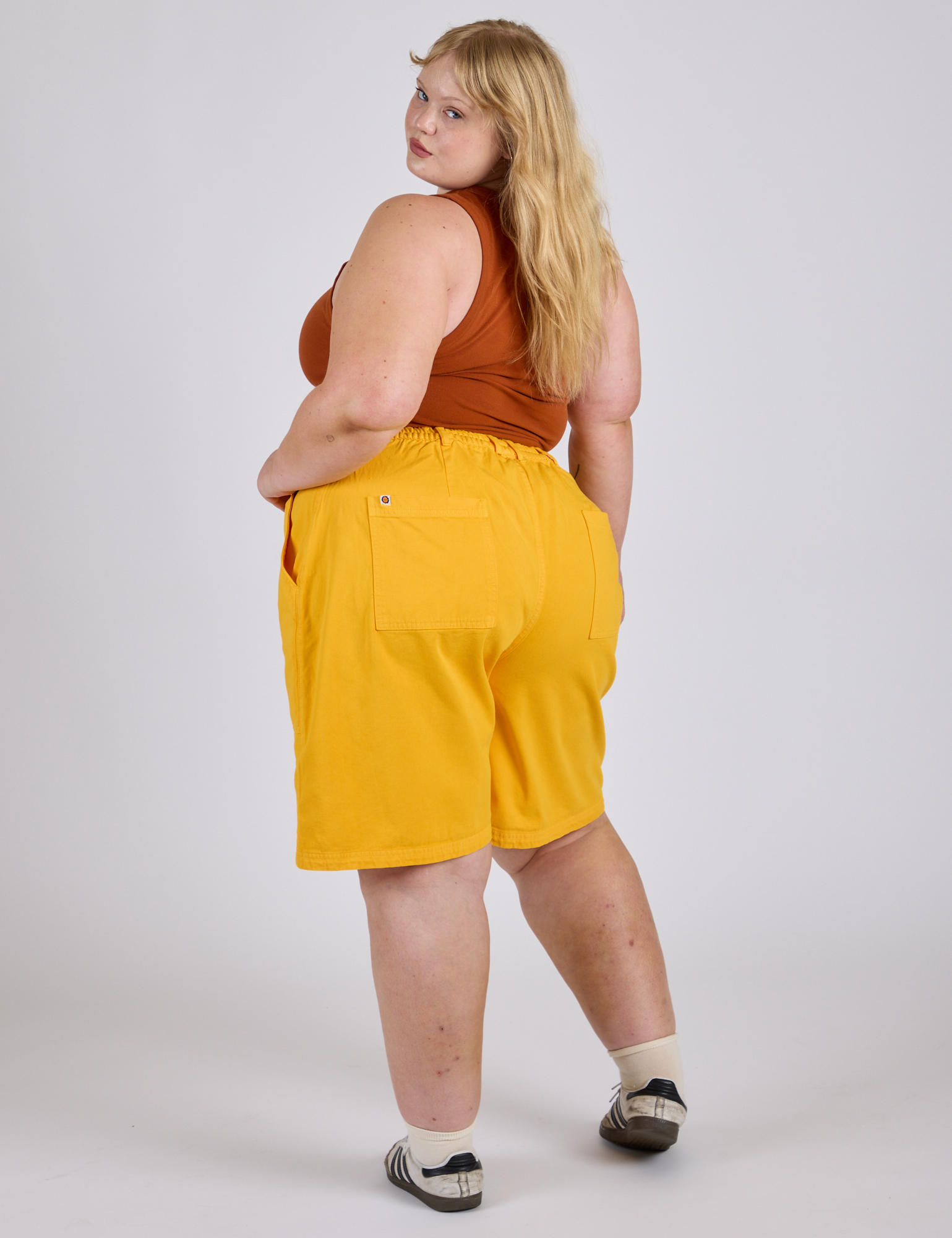 Longline Work Shorts in Sunshine Yellow angled back view on Juliet