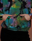 Alex has her hands in the front kangaroo pocket of Oversized Hoodie in Rainbow Magic Waters