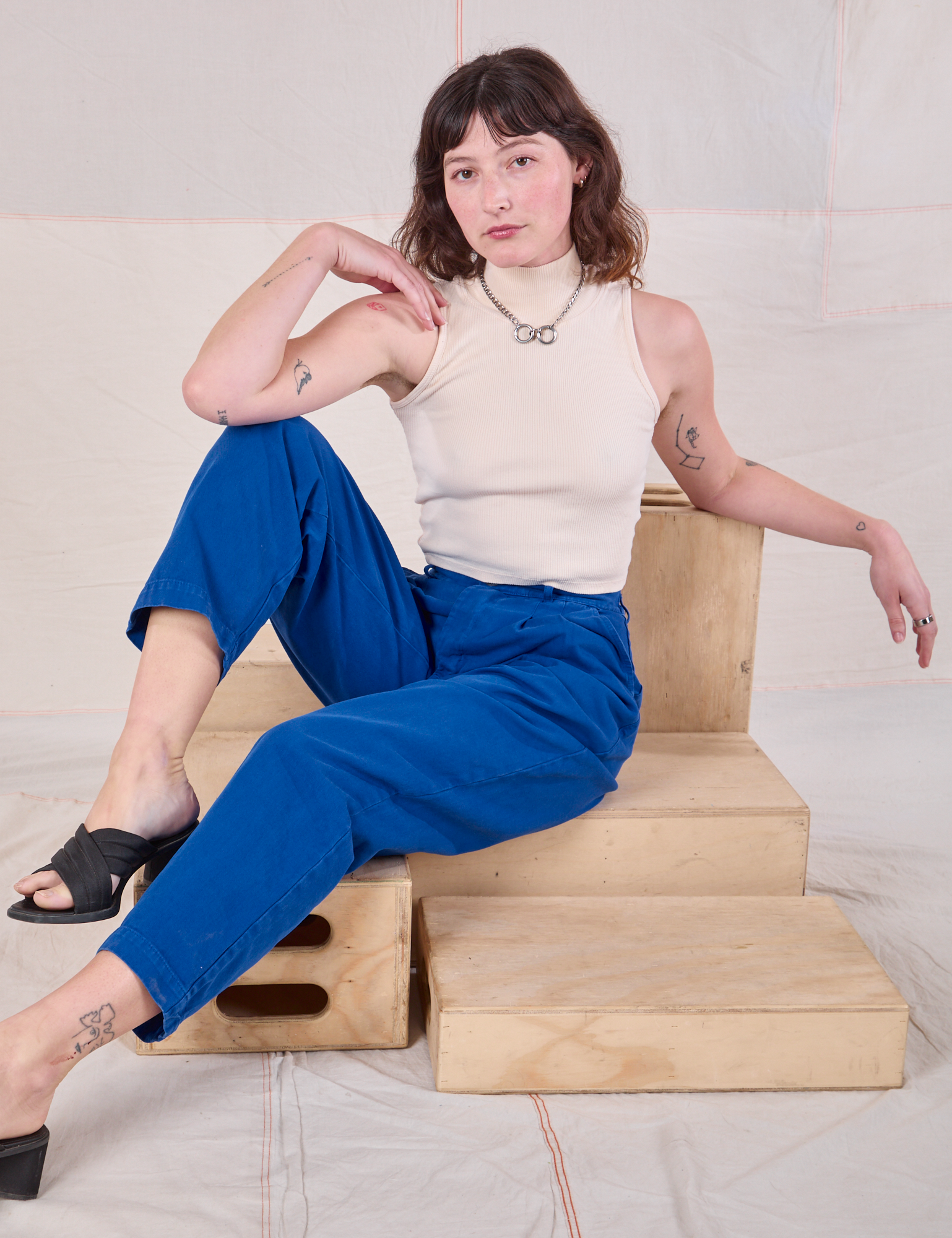 Alex is wearing Heavyweight Trousers in Royal Blue and Sleeveless Turtleneck in Vintage tee Off-White