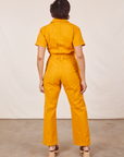 Back view of Short Sleeve Jumpsuit in Mustard Yellow worn by Tiara