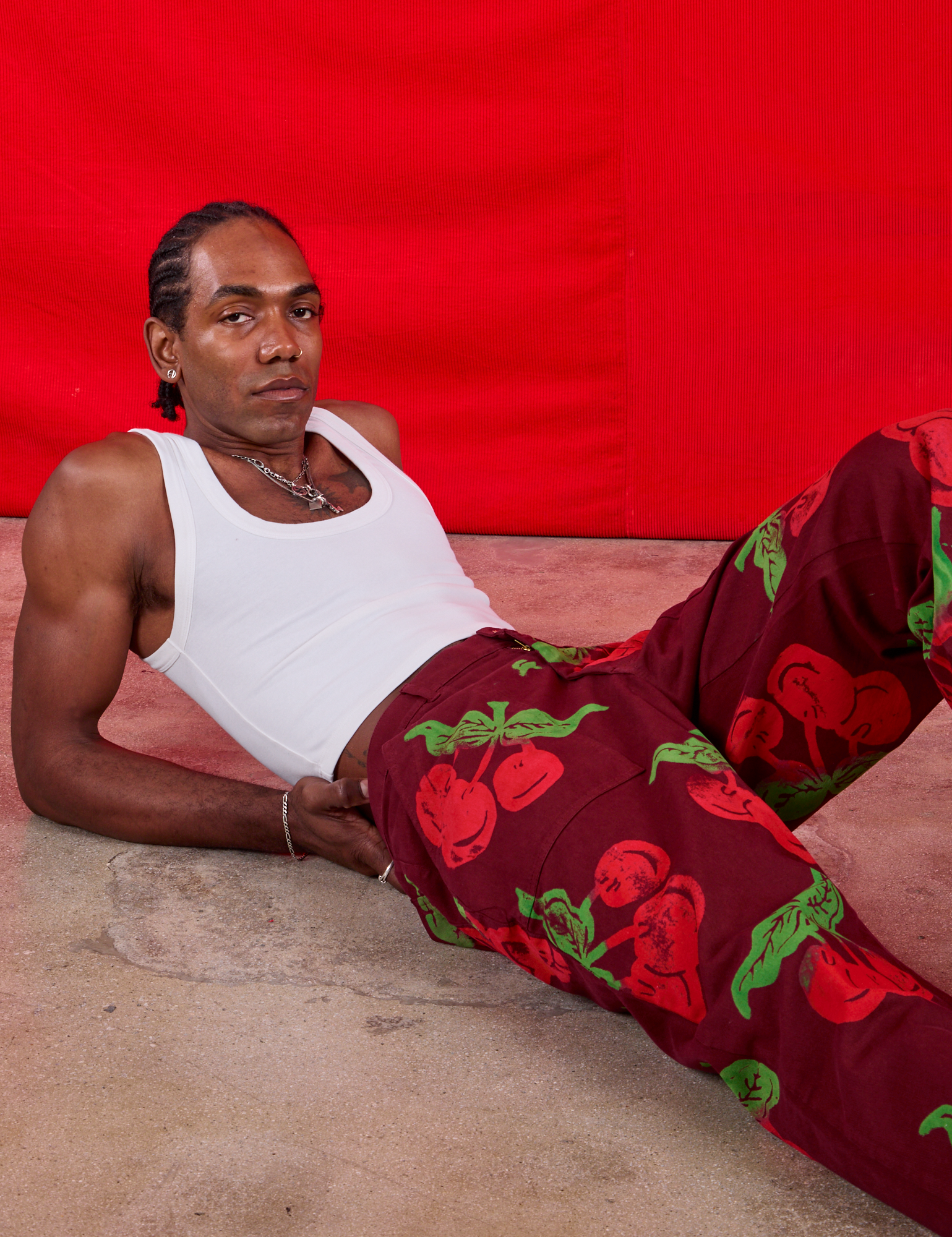 Jerrod is wearing Paintstamped Work Pants in Cherry and Cropped Tank in vintage tee off-white