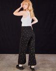 Angled back view of Star Bell Bottoms in Black and Cropped Tank in vintage tee off-white on Margaret