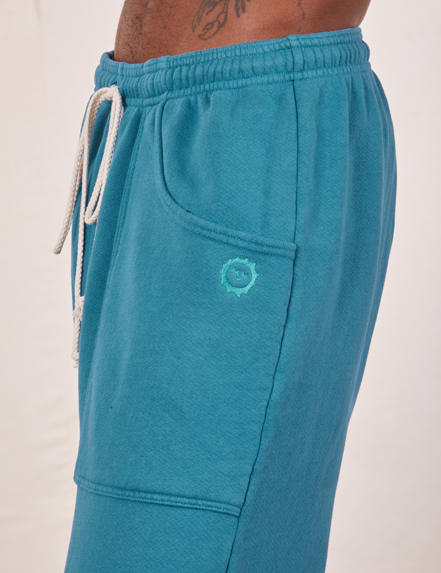 Side view close up of Cropped Rolled Cuff Sweatpants in Marine Blue on Jerrod