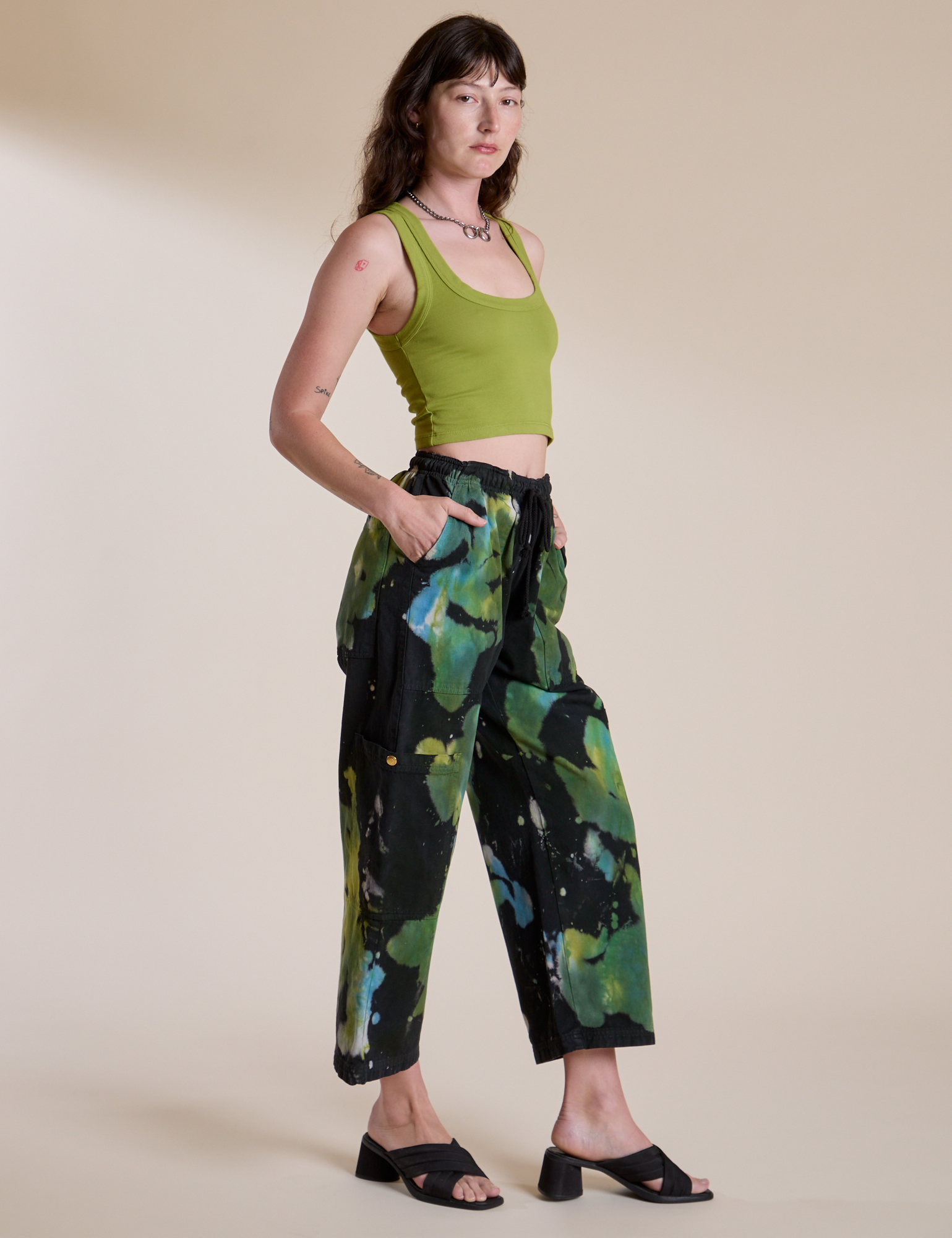 Side view of Magic Waters Drop Pocket Pants in Green Pool and gross green Cropped Tank on Alex