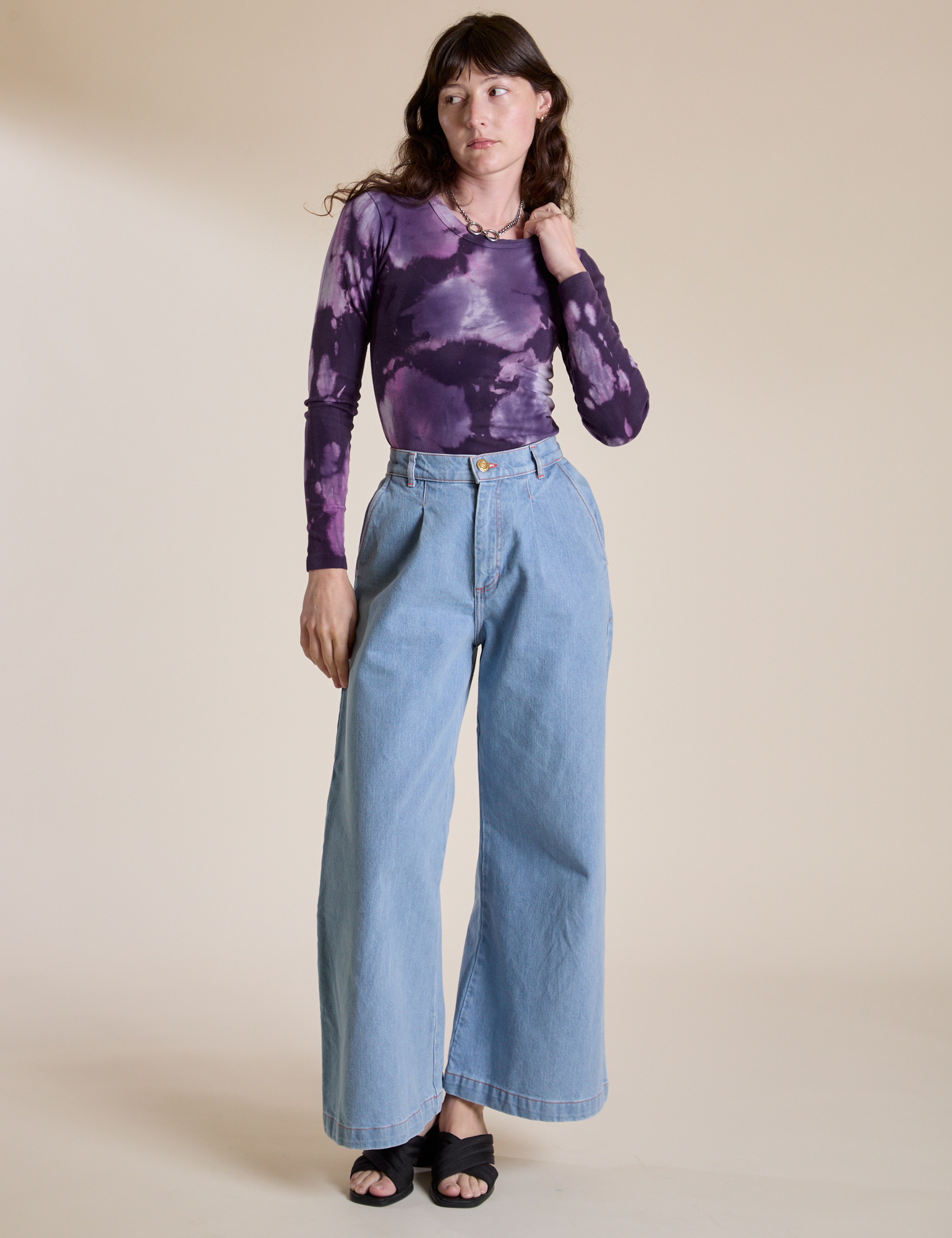 Alex is wearing Long Sleeve Baby Tee in Dark Lavender and light wash Wide Leg Trousers
