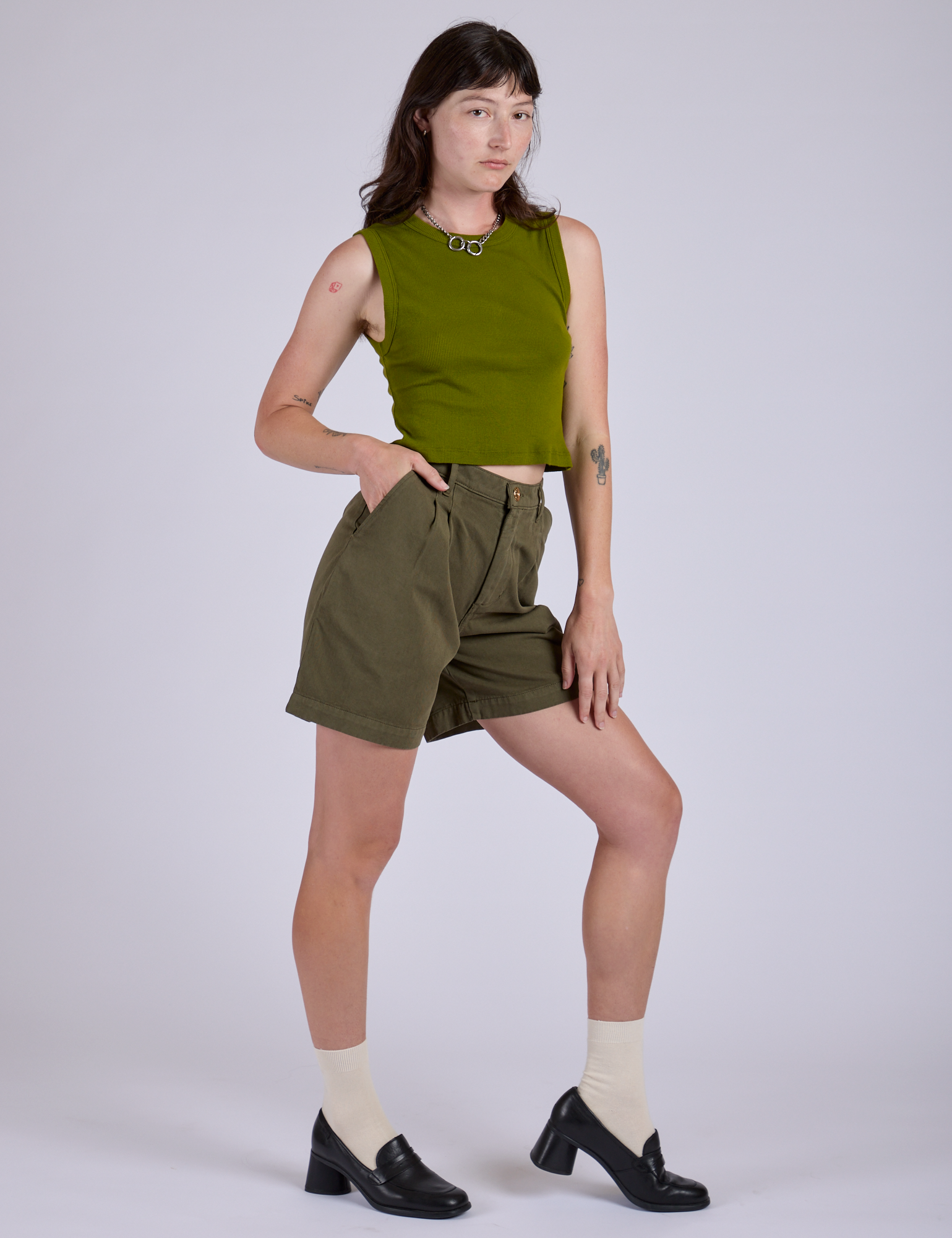 Angled front view of Pleated Trouser Shorts in Surplus Green and summer olive Muscle Tee
