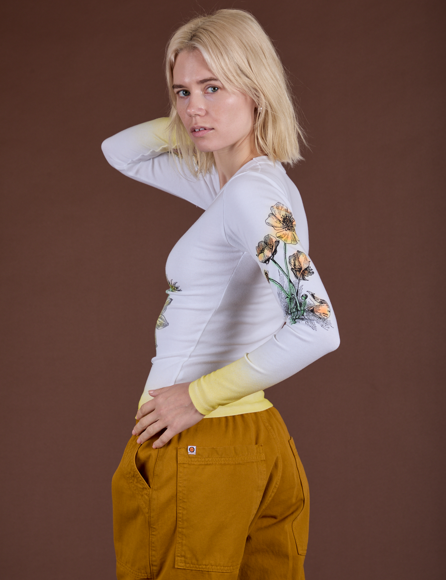 Side view of Floral Long Sleeve Baby Tee in Yellow with focus on the screen print sleeve