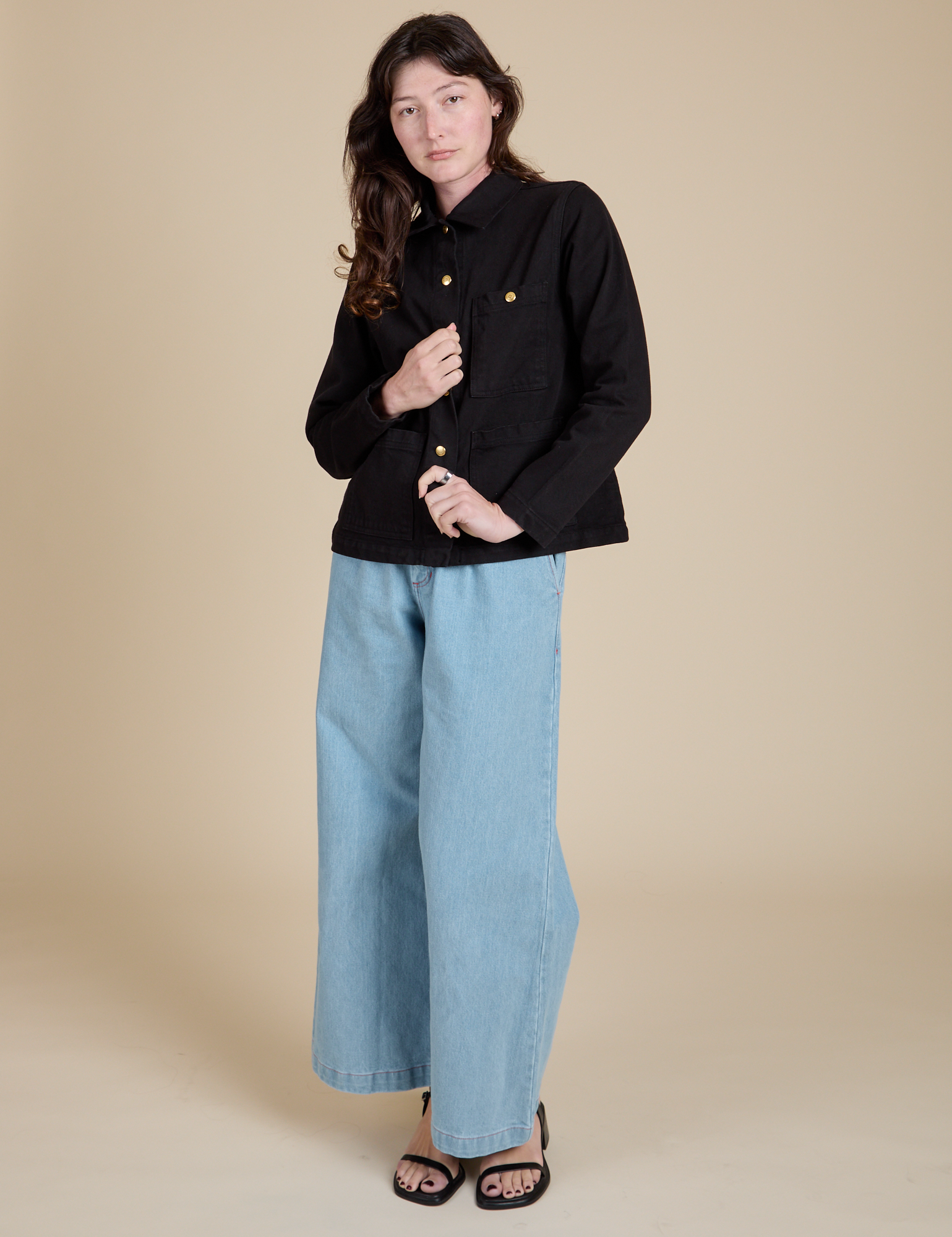 Alex is wearing Work Jacket in Basic Black and light wash Indigo Wide Leg Trousers