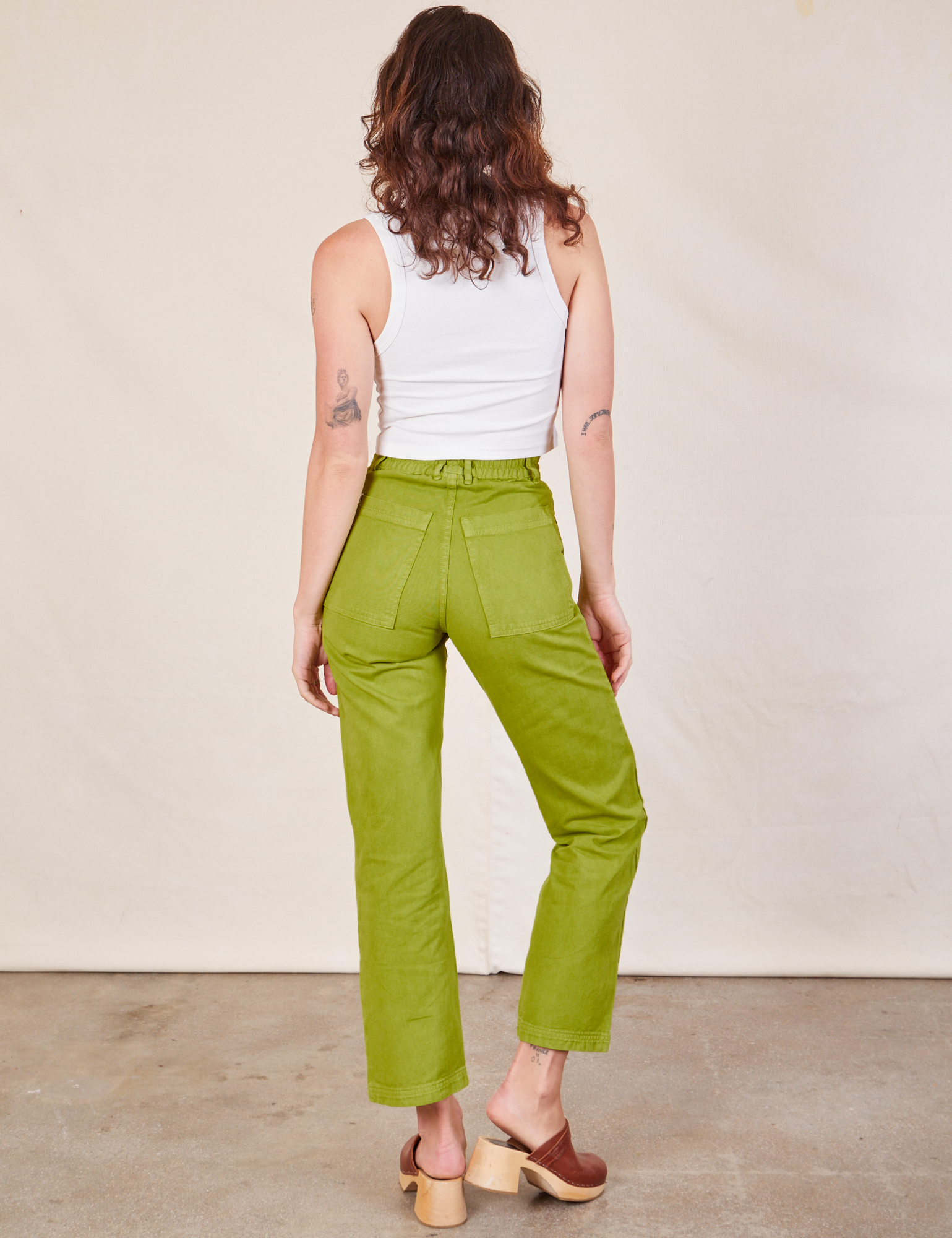 Back view of Work Pants in Gross Green and Cropped Tank in vintage tee off-white on Alex