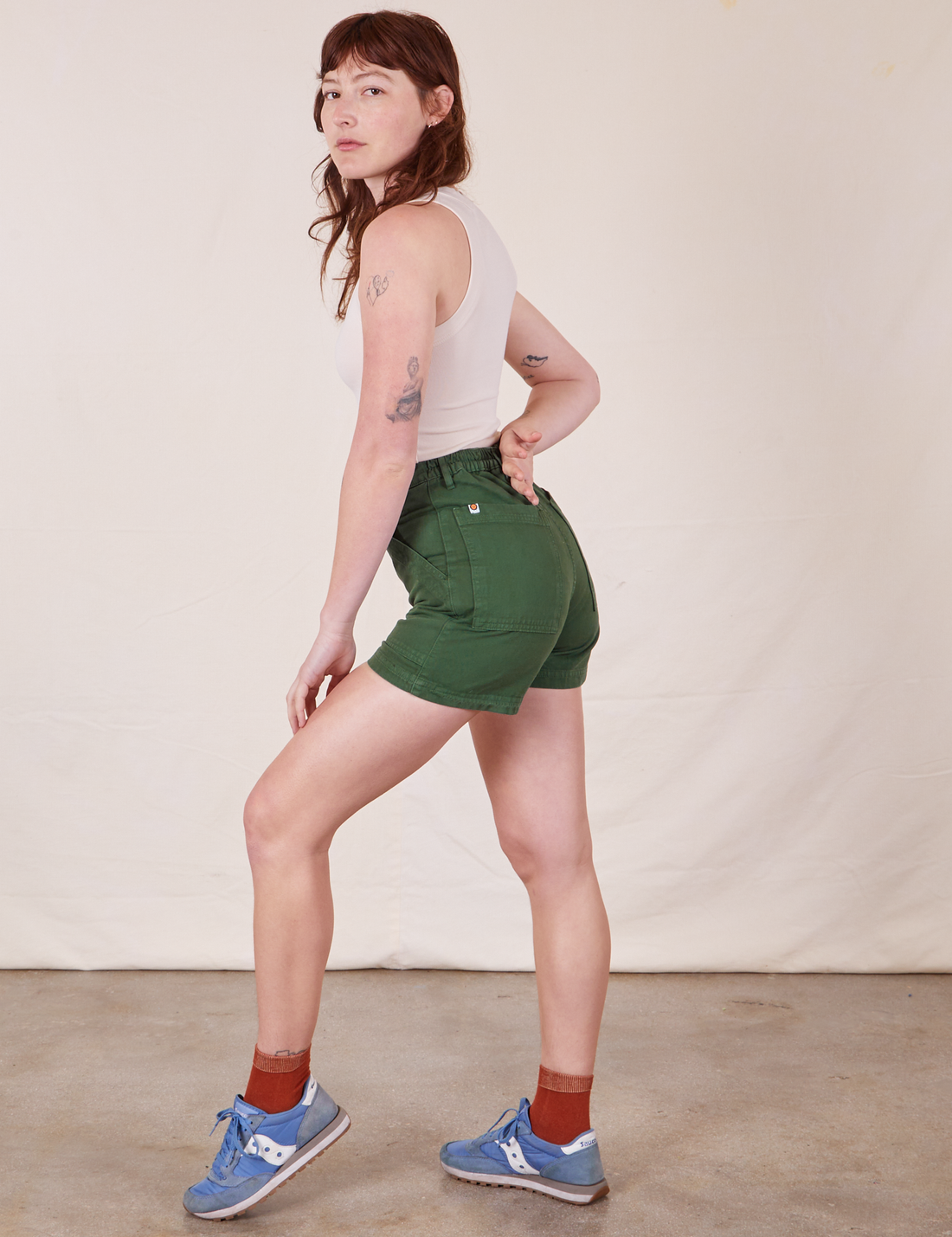 Side view of Classic Work Shorts in Dark Emerald Green and vintage off-white Tank Top worn by Alex