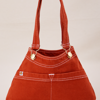 Overall Handbag in Paprika with handles standing up.