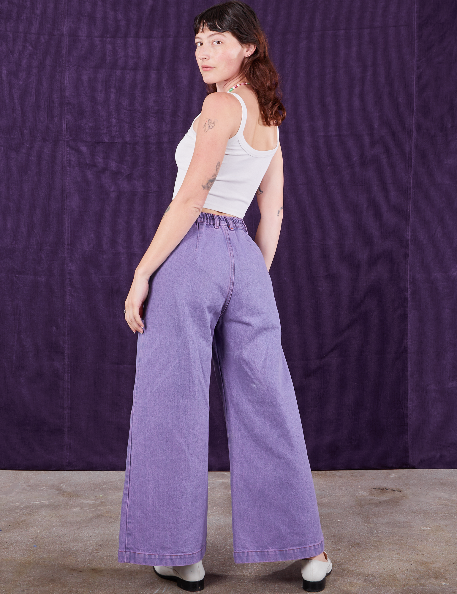 Angled back view of Overdyed Wide Leg Trousers in Faded Grape and vintage off-white Cami