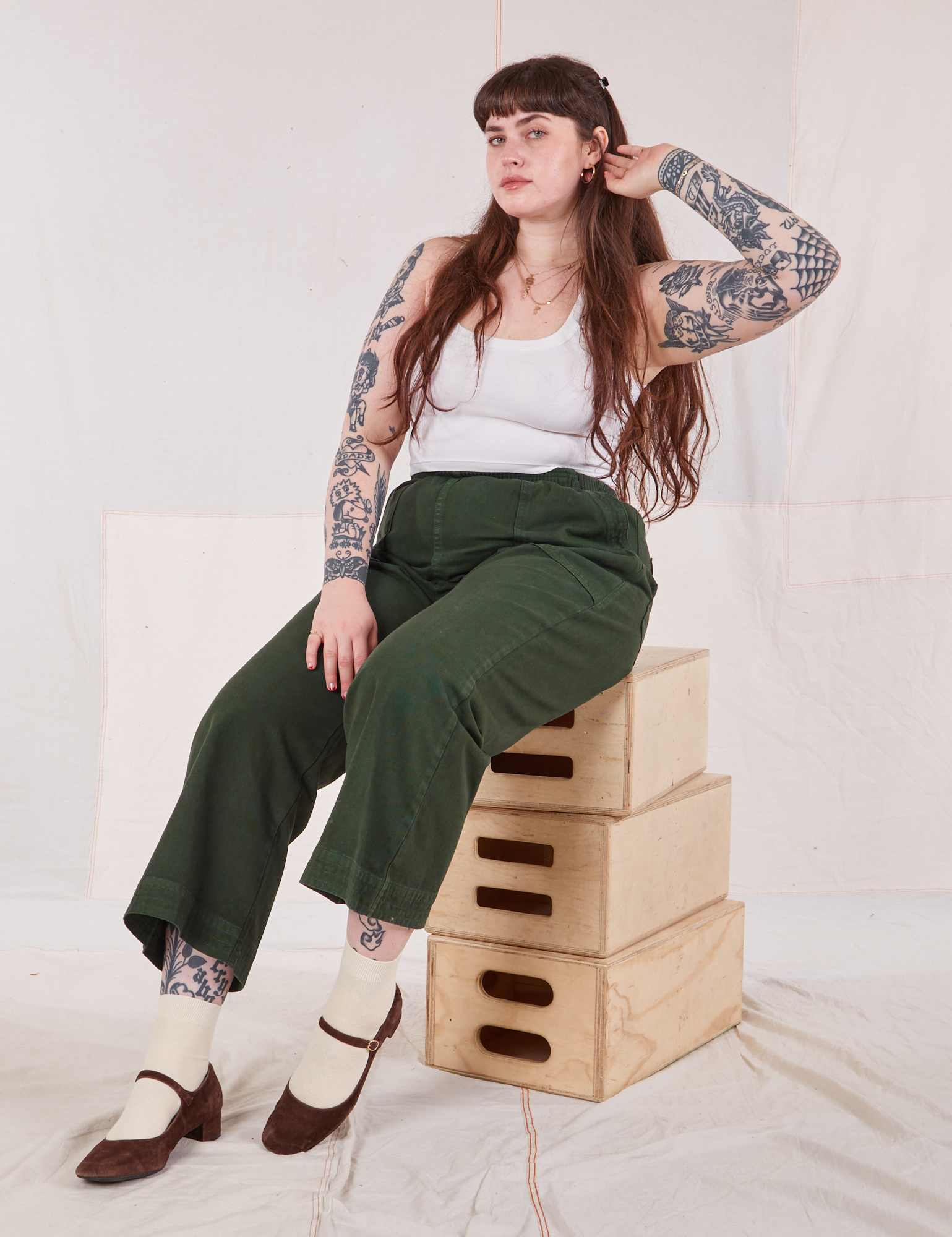 Sydney is wearing Action Pants in Swamp Green and Cropped Tank in vintage tee off-white