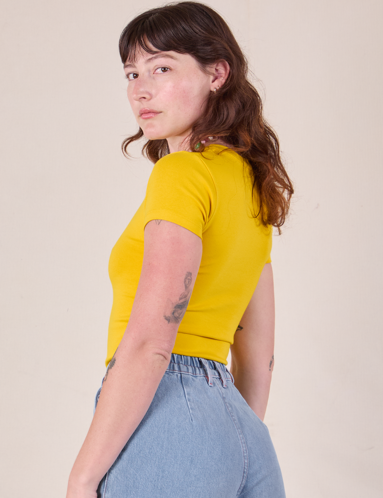 Baby Tee in Golden Yellow angled back view on Alex