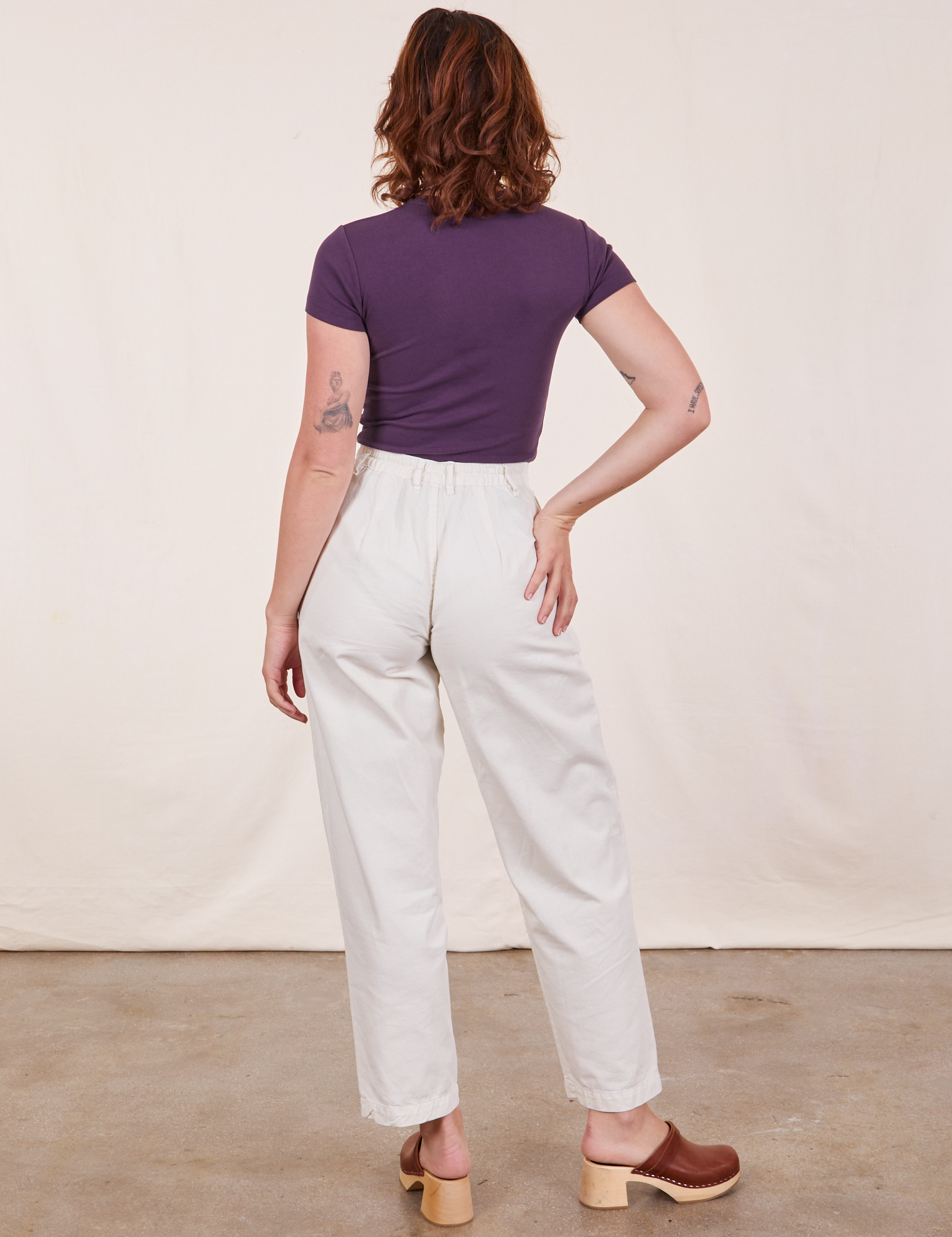 Back view of Baby Tee in Nebula Purple and vintage off-white Trousers worn by Alex