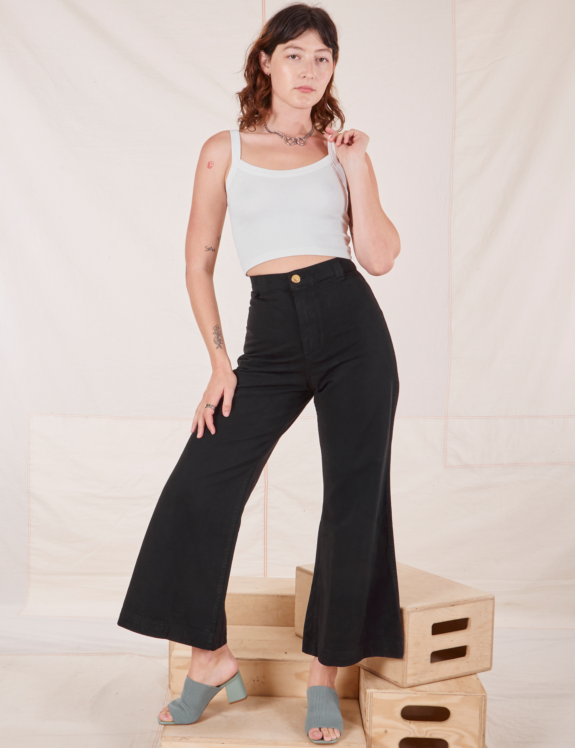 Alex is 5&#39;8&quot; and wearing XXS Bell Bottoms in Basic Black paired with vintage off-white Cami