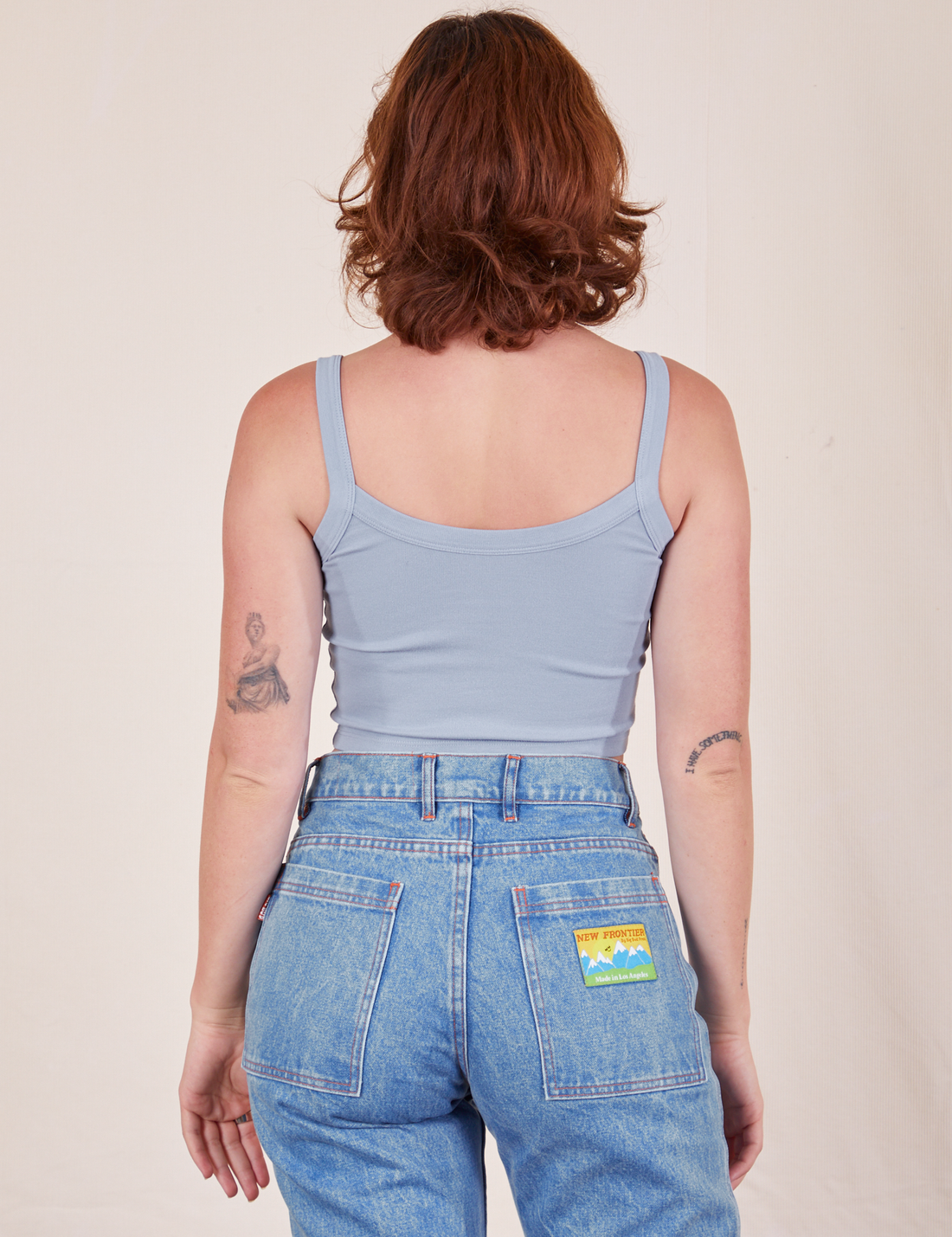 Back view of Cropped Cami in Periwinkle and light wash Frontier Jeans worn by Alex