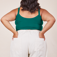 Back view of Cropped Cami in Hunter Green and vintage off-white Western Pants worn by Alicia. She has both hands in the back pant pockets.