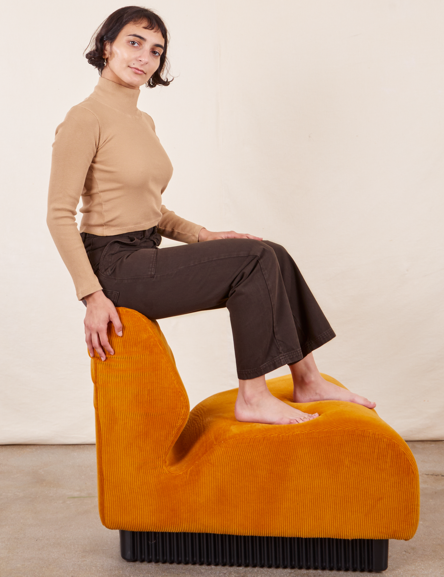 Side view of Work Pants in Espresso Brown on Soraya wearing tan Essential Turtleneck.