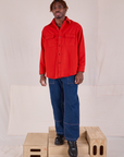 Isaac is wearing Flannel Overshirt in Mustang Red paired with dark wash Carpenter Jeans