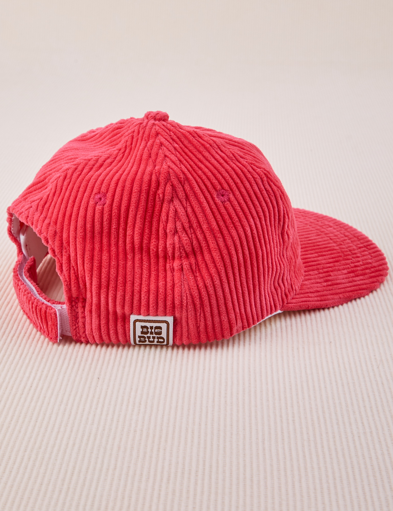 Side view of Dugout Corduroy Hat in Hot Pink. Big Bud label sewn on the side.