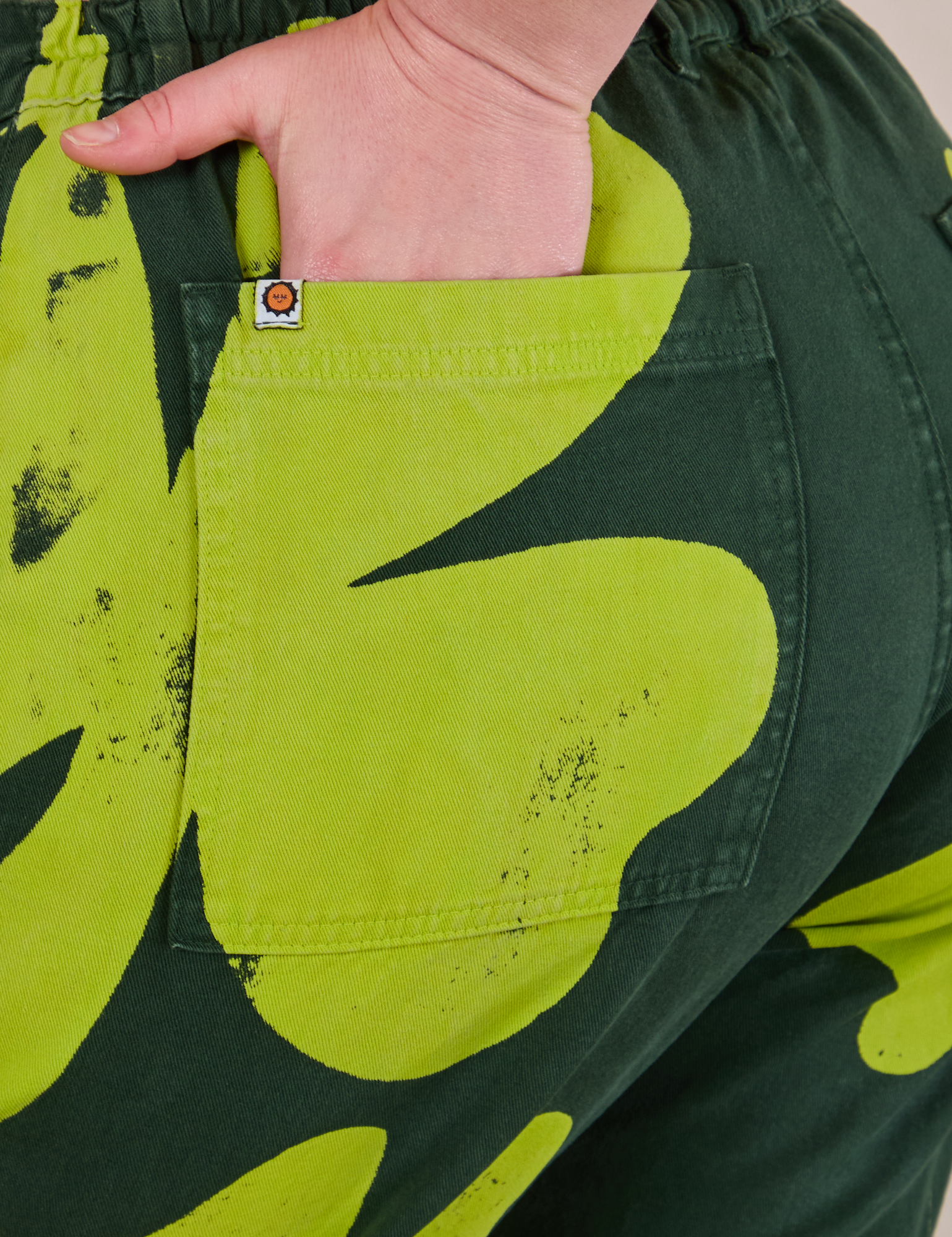 Close up of Lish&#39;s hand in the back pocket of Paintstamped Clover Work Pant