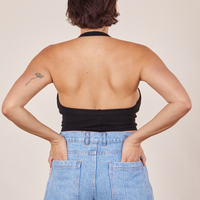 Back view of Halter Top in Basic Black and light wash Frontier Jeans worn by Tiara