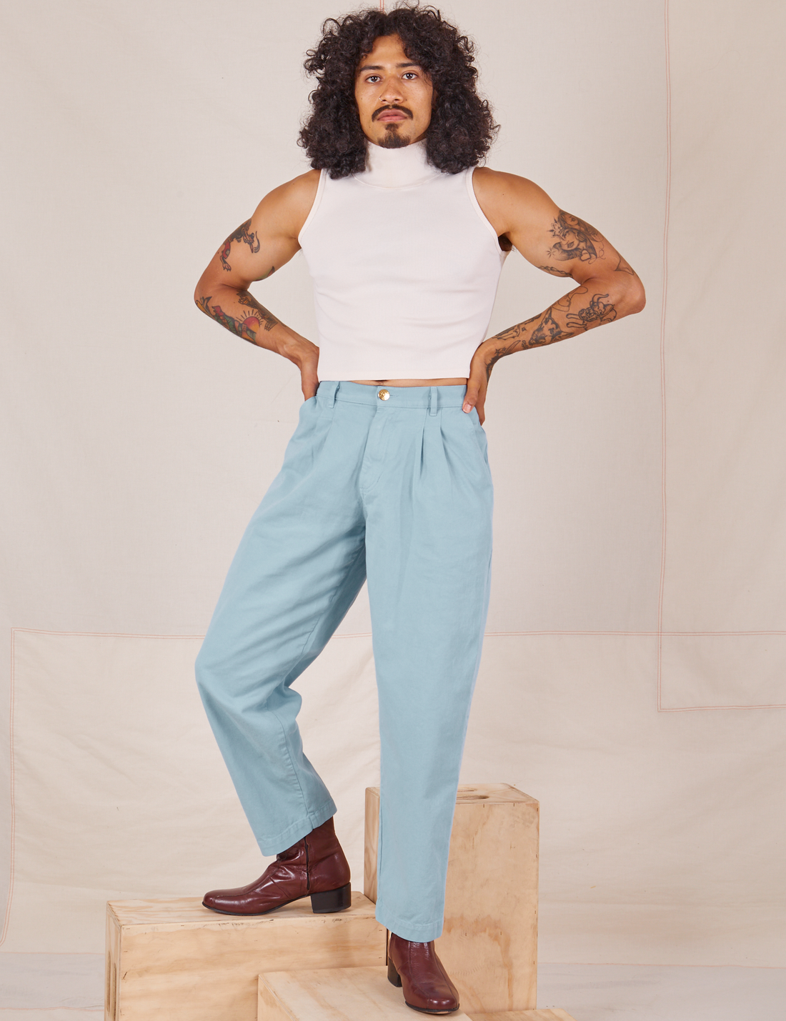 Jesse is 5'8" and wearing XXS Heavyweight Trousers in Baby Blue paired with vintage off-white Sleeveless Turtleneck