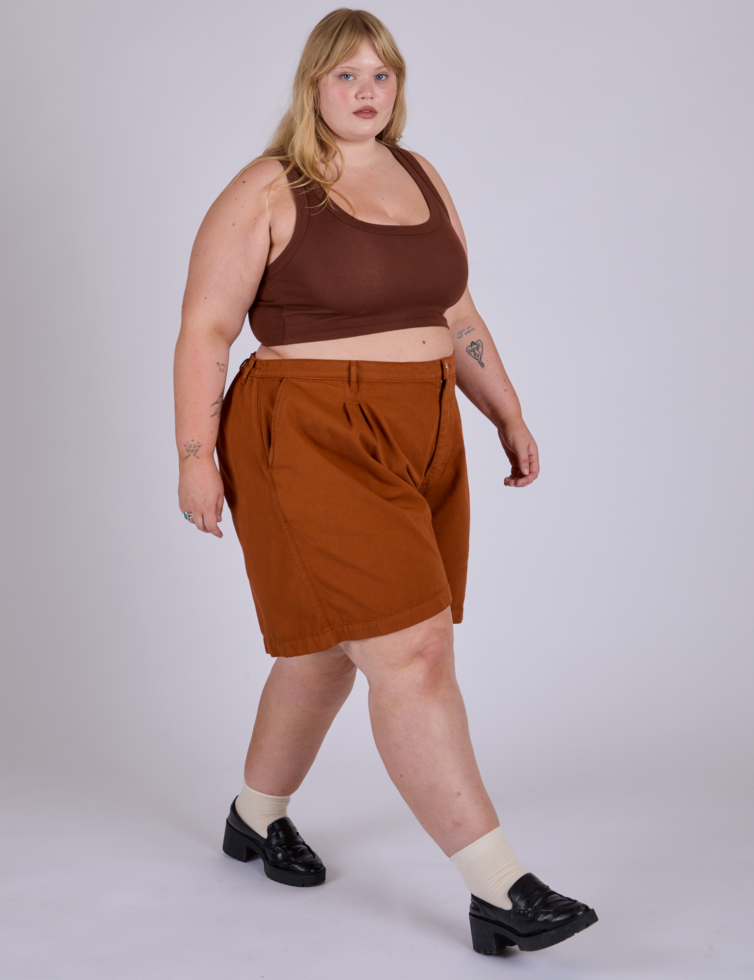 Angled front view of Pleated Trouser Shorts in Burnt Terracotta and fudgesicle brown Mini Tank on Juliet