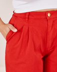 Front pocket close up of Heavyweight Trousers in Mustang Red. Tiara has her hand in the pocket.