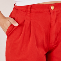 Front pocket close up of Heavyweight Trousers in Mustang Red. Tiara has her hand in the pocket.