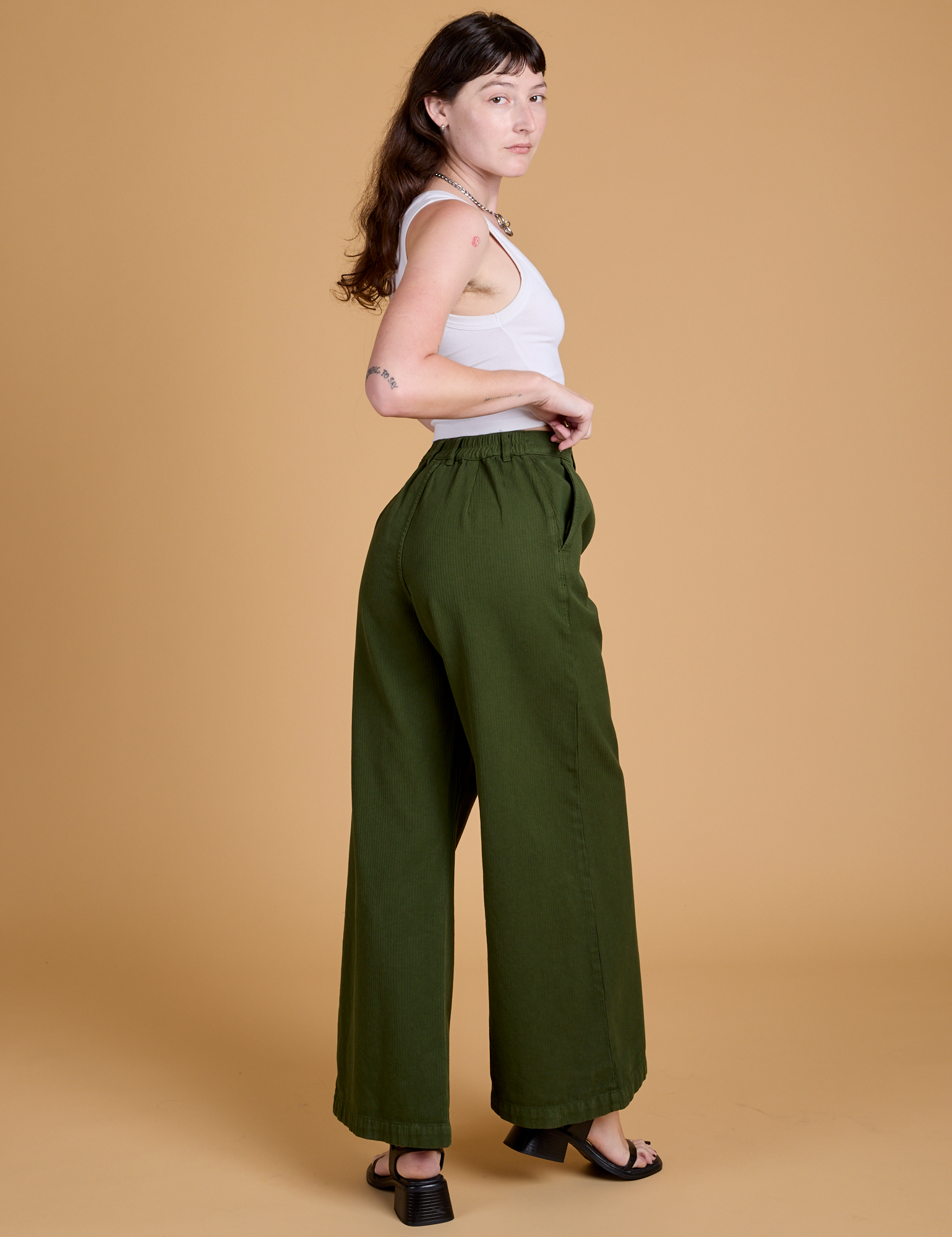 Angled back view of Heritage Wide Leg Trousers in Evergreen on Alex