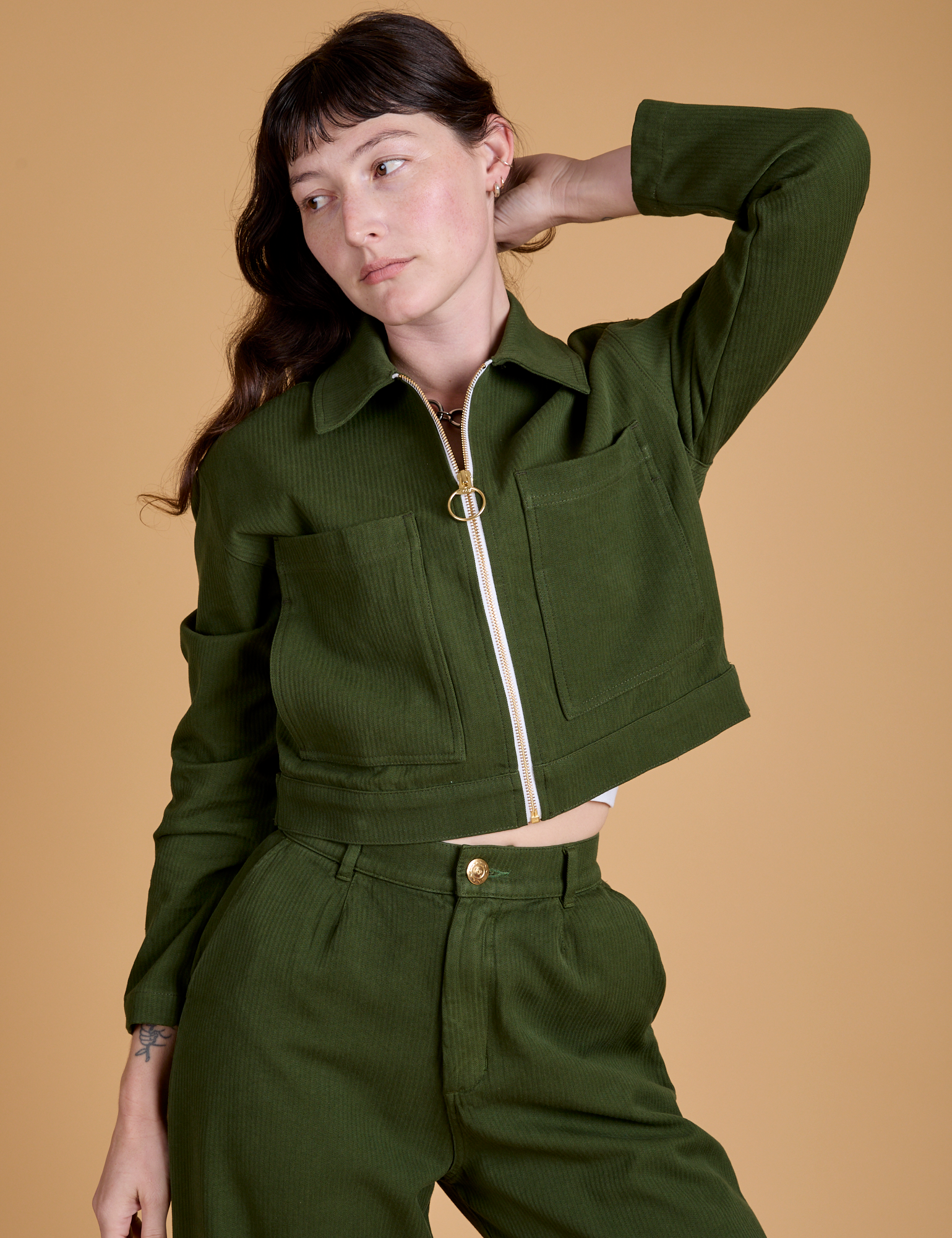 Alex is wearing a zipped up Heritage Mechanic Jacket in Evergreen