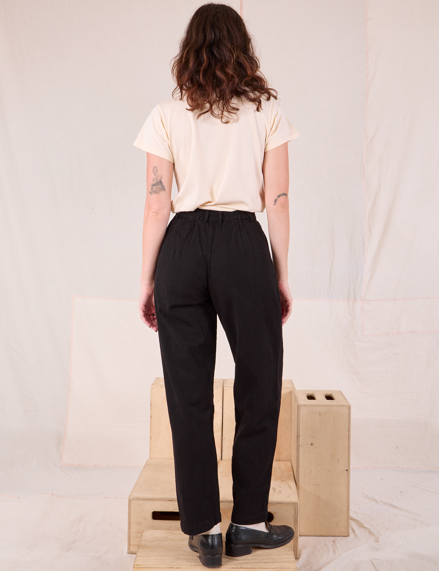 Back view of Heritage Trousers in Basic Black and Organic Vintage Tee in vintage tee off-white on Alex