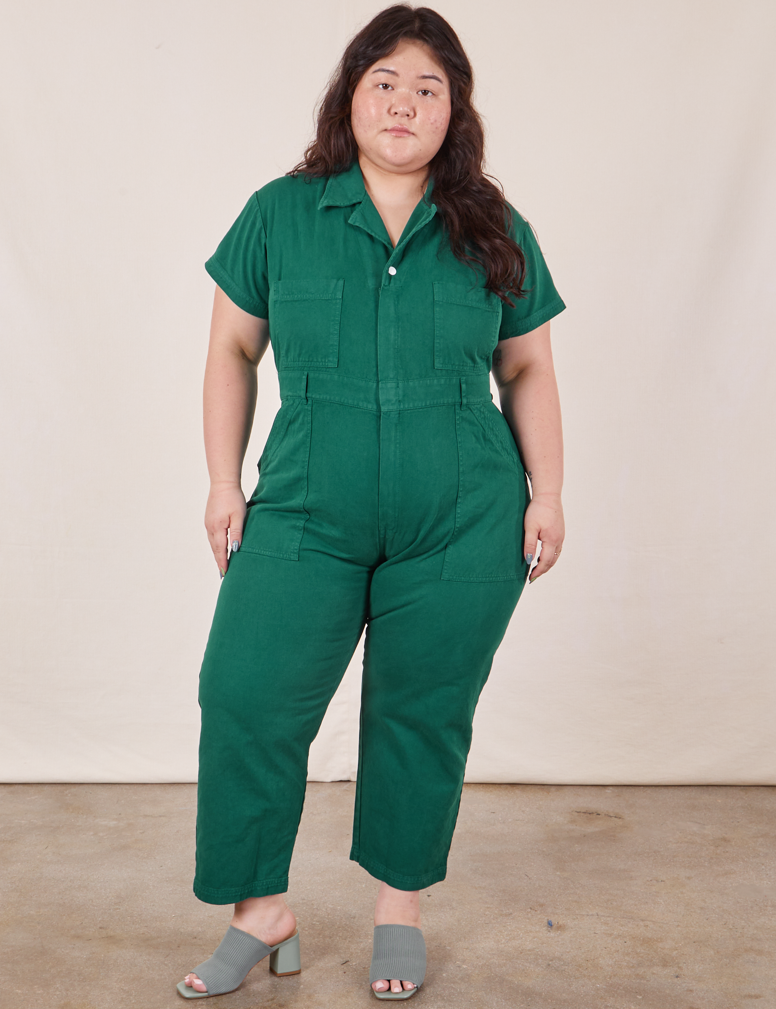 Ashley is 5’7” and wearing 1XL Petite Short Sleeve Jumpsuit in Hunter Green 