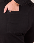 Long Sleeve Jumpsuit in Basic Black back pocket close up. Juliet has her hand in the pocket.