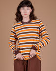 Alex is wearing Long Sleeve Striped Burly Tee in Orange