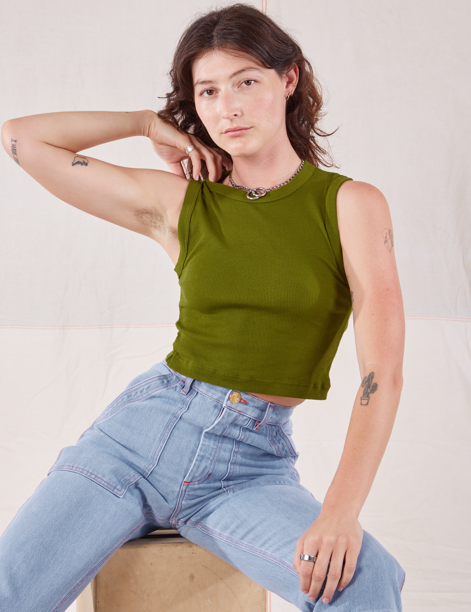 Alex is wearing Muscle Tee in Summer Olive and light wash Carpenter Jeans