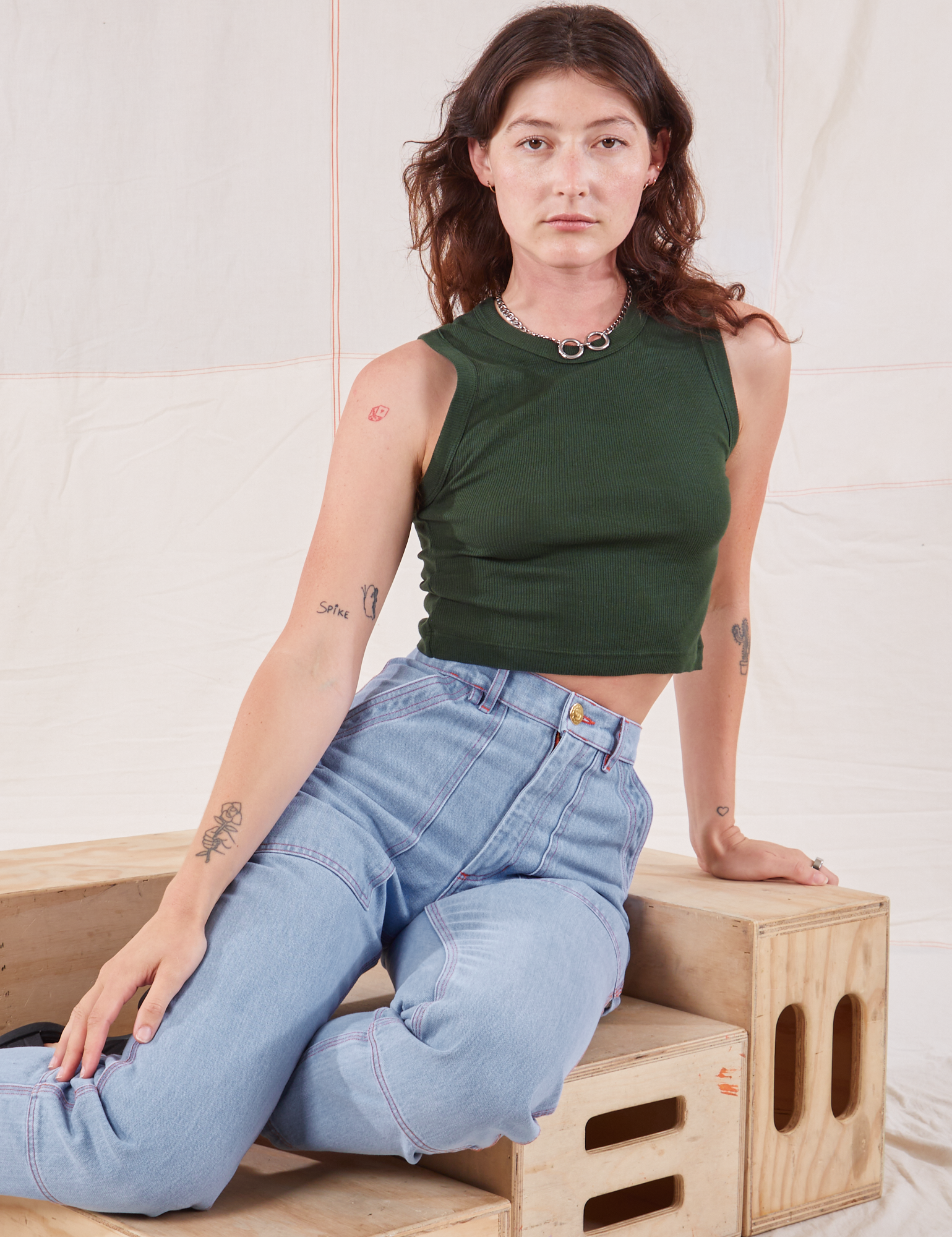 Alex is wearing Muscle Tee in Swamp Green and Carpenter Jeans in light wash