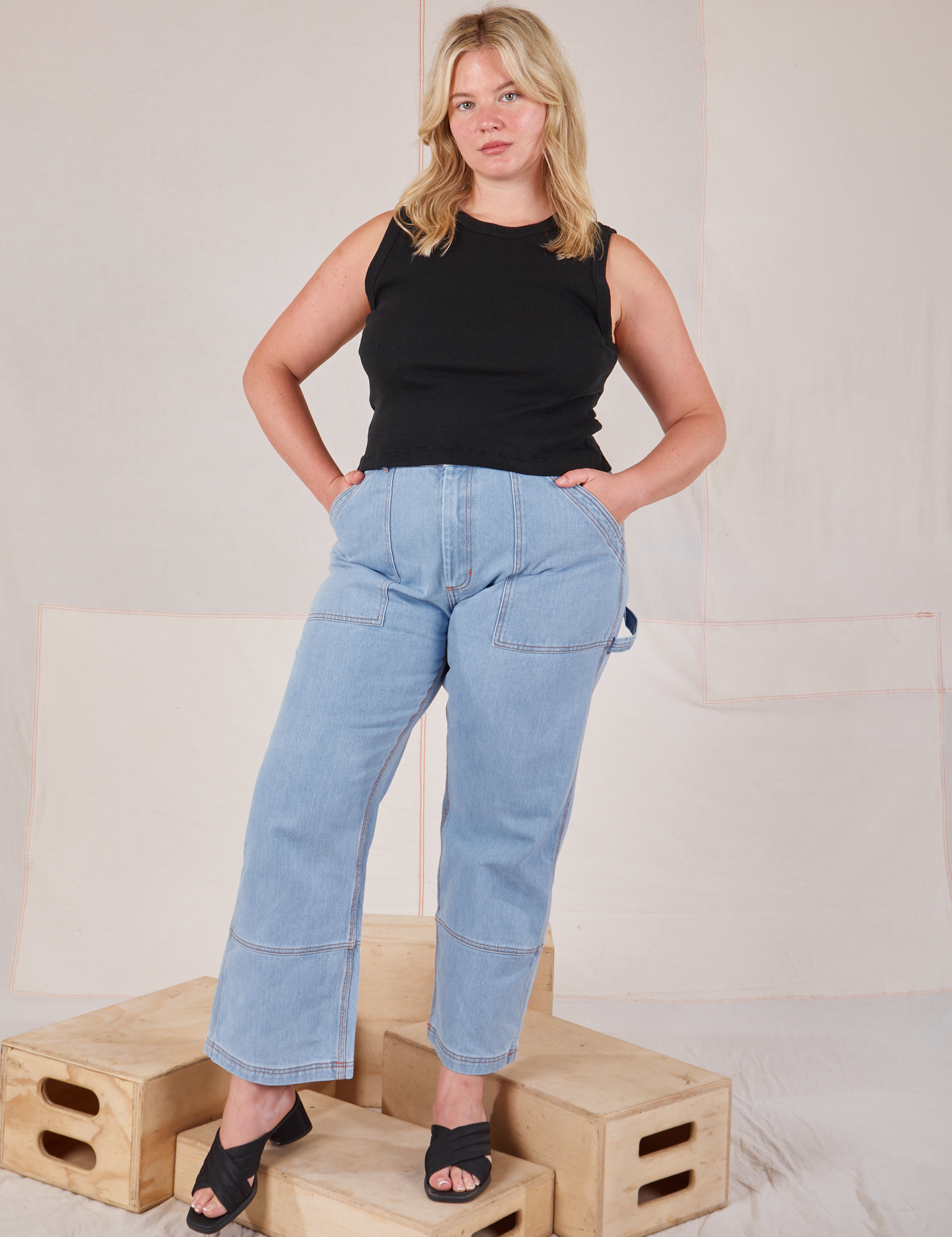 Lish is wearing Muscle Tee in Basic Black and light wash Carpenter Jeans