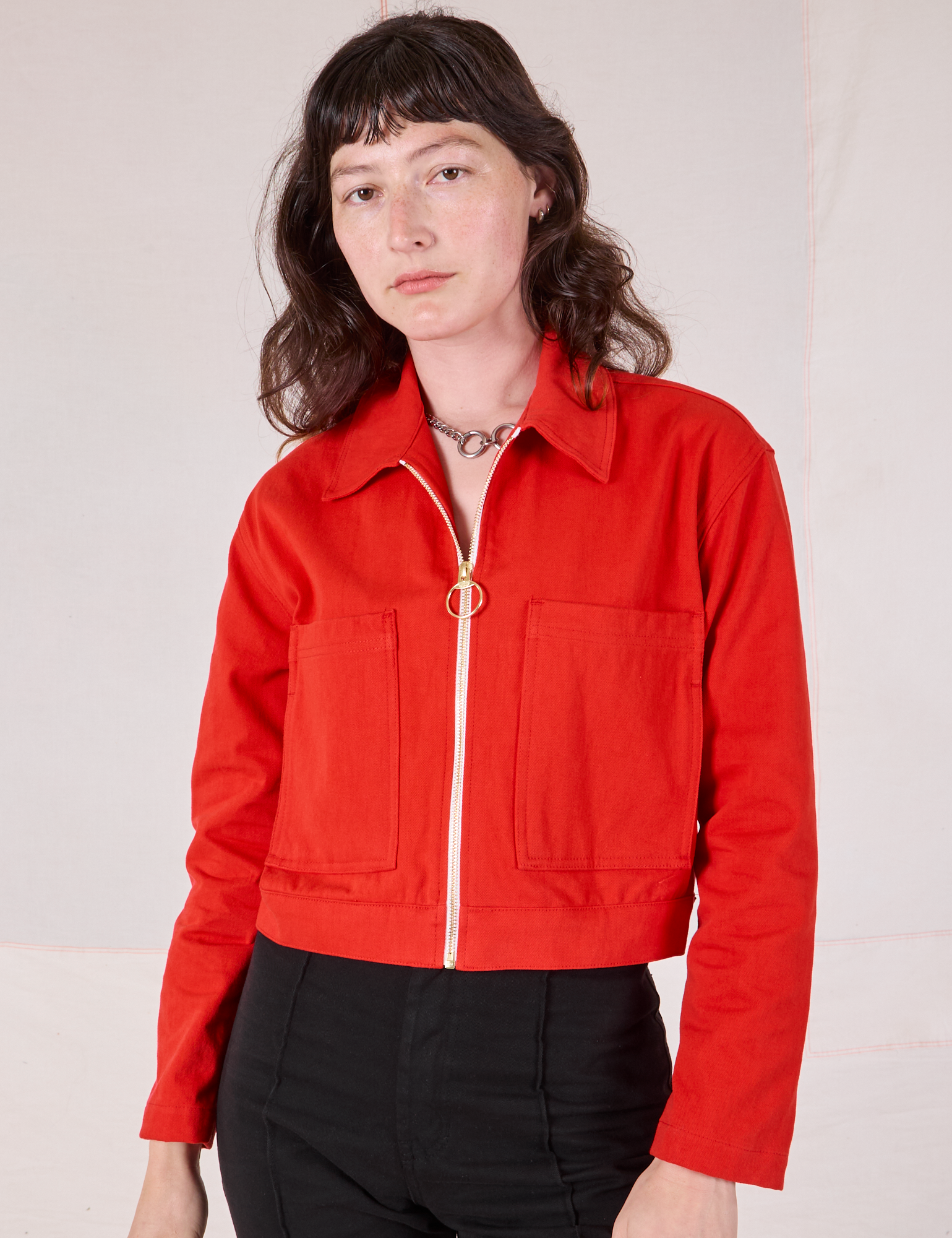 Alex is wearing a zipped up Mechanic Jacket in Mustang Red