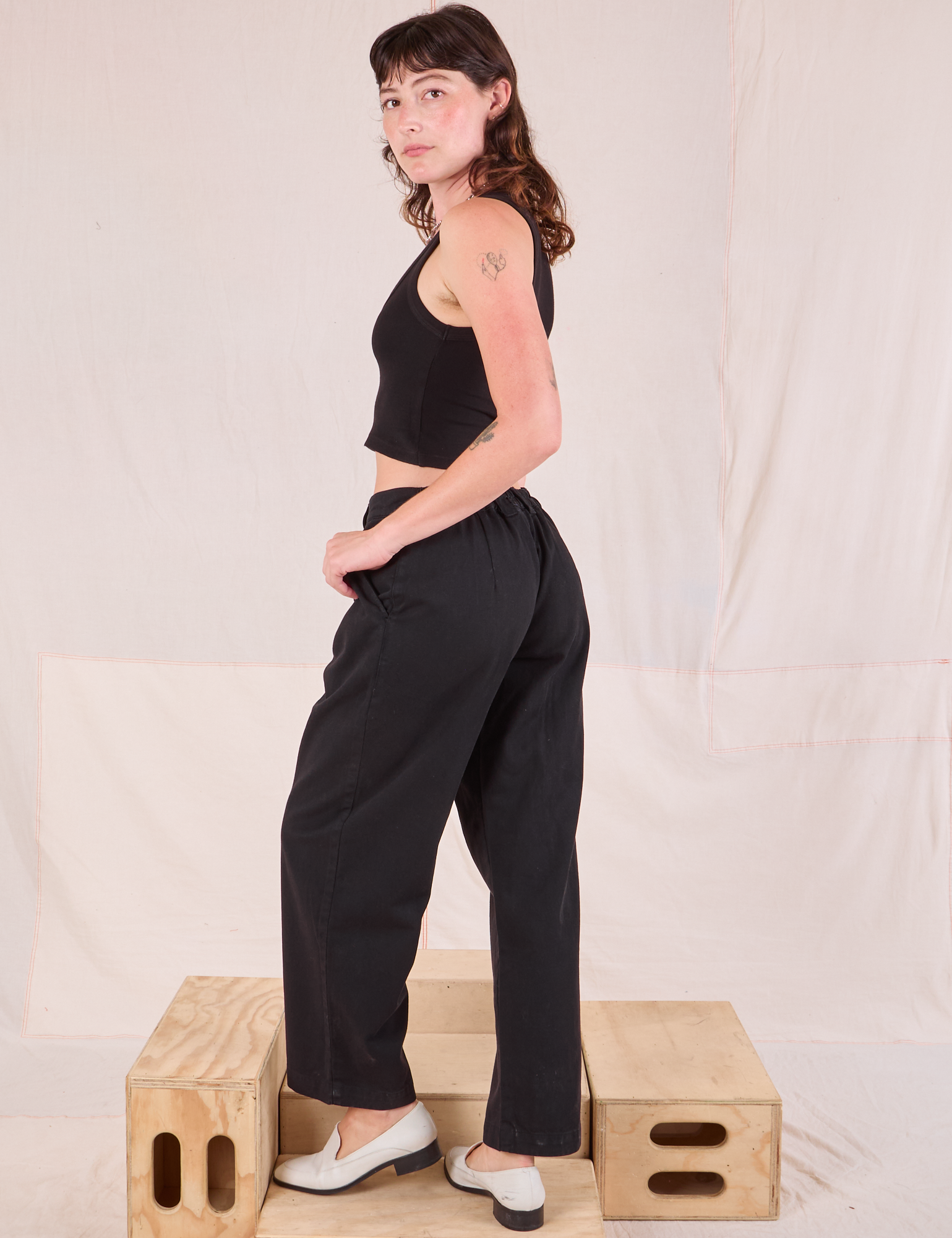 Angled back view of Mid-Rise Pleated Trousers in Basic Black on Alex