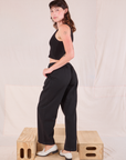 Angled back view of Mid-Rise Pleated Trousers in Basic Black on Alex