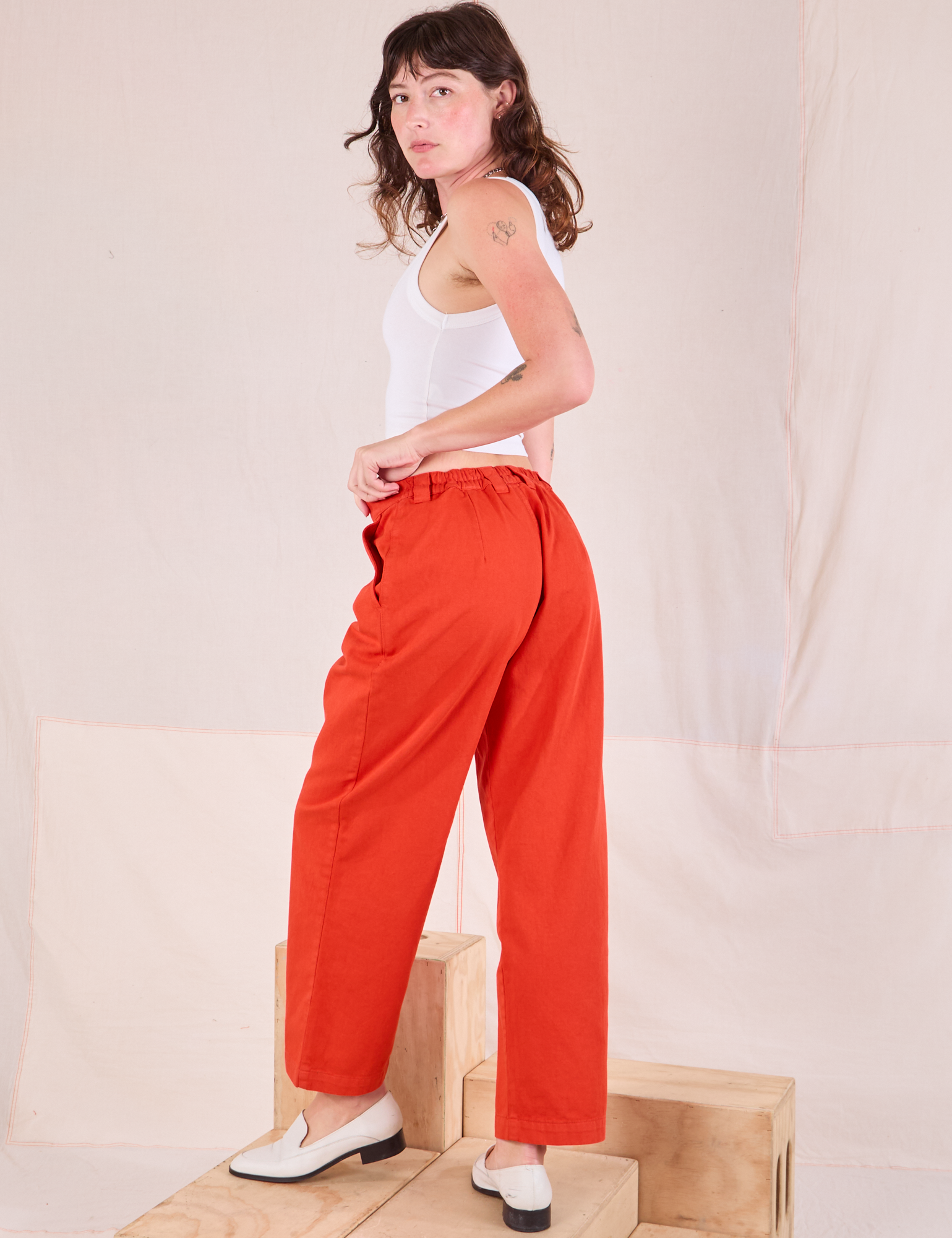 Mid-Rise Pleated Trousers in Chili Red angled back view on Alex