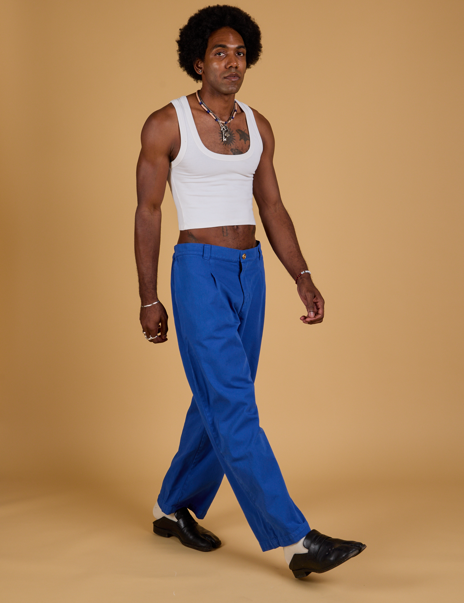 Angled front view of Baggy Mid-Rise Trousers in Royal Blue and vintage tee white Cropped Tank on Jerrod